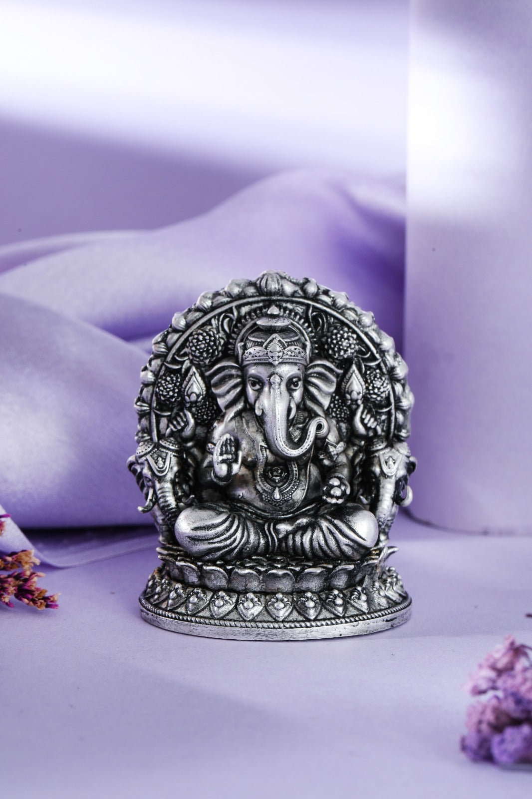 Silver Ganesha idol seated in arched throne